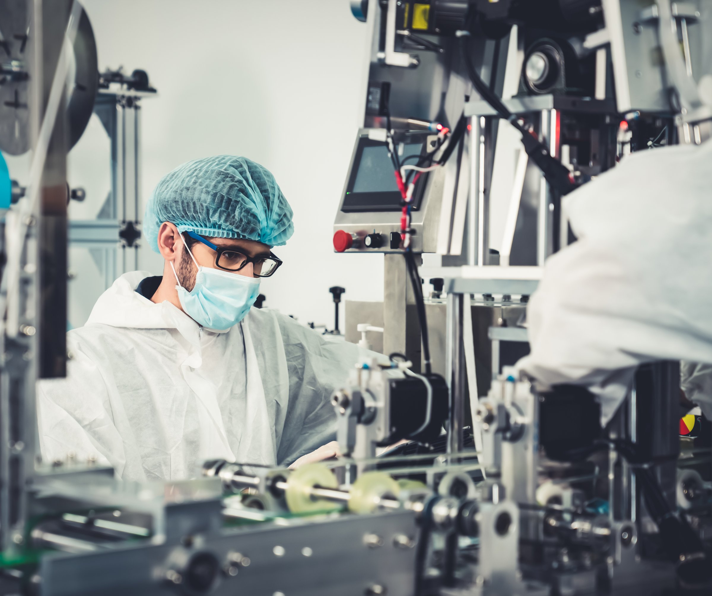 Production line worker with face mask working in electronic factory